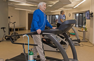 Two cardiopulmonary rehabilitation patients walking on treadmills in the cardiac rehab gym