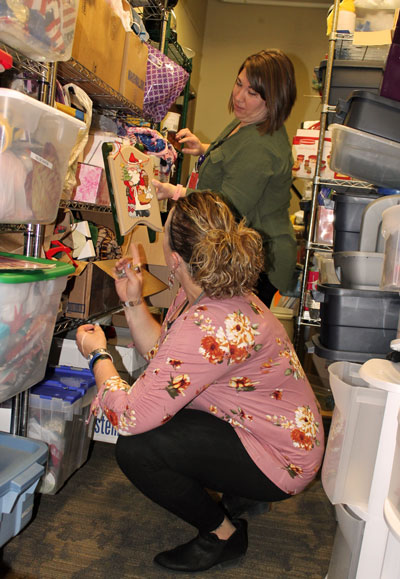 Activities Assistant Jessie Kuechenmeister shows one of the items gathered so far for The Neighborhoods at Brookview’s seventh annual Resident Christmas Store to Activities Coordinator Amanda Uecker. The store, which will be open Dec. 5 and 6, provides donated items nursing home residents may choose from free-of-cost to give as presents to their loved ones. Community members interested in giving to the store may drop off donated items at The Neighborhoods up until Dec. 4. Those interested in volunteering with the store may contact Uecker at (605) 696-8716 or auecker@brookingshealth.org or Kuechenmeister at (605) 696-8753 or jkuechenmeister@brookingshealth.org.