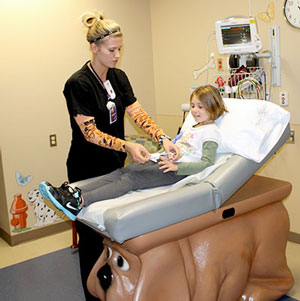 Nurse examining child in pediatric emergency room
