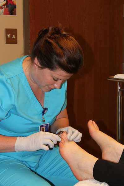 Foot Care Nurse Mandy Odegaard examines a patient’s feet.