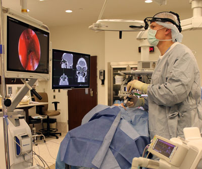 ENT Surgeon Dr. Jonathan Mellema performs image-guided sinus surgery and looks at a patient's sinus and nasal cavities via two computer screens.
