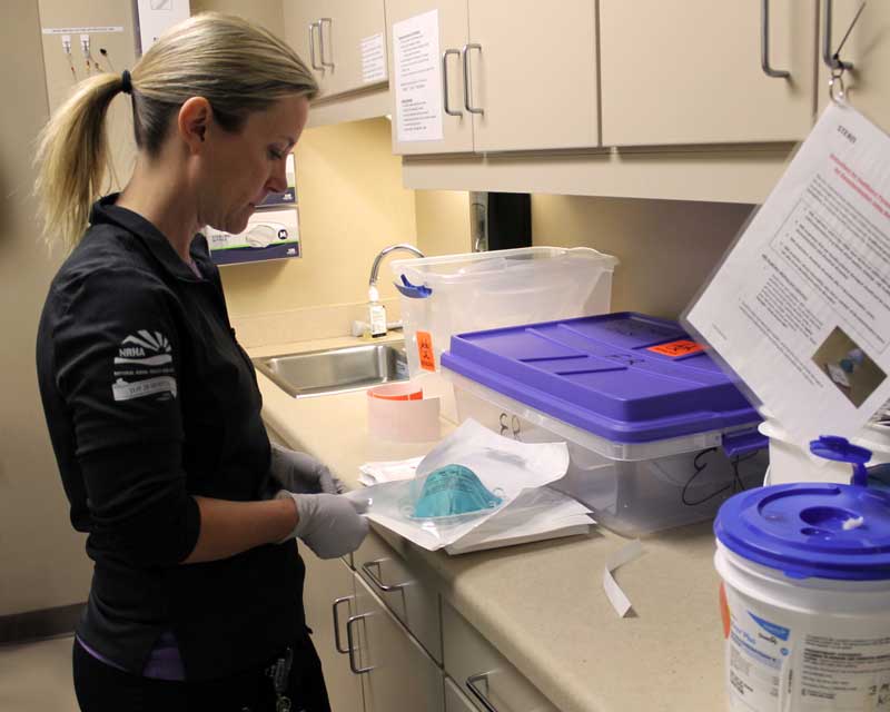 Emergency Department Nurse Celene Hirschoff, RN, places her N95 mask inside a breathable pouch to be processed for decontamination. Brookings Health System recently started using vaporized hydrogen peroxide to decontaminate and conserve N95 respiratory masks for staff reuse. Team members pouch and label their masks after their shift. Masks are then placed inside Brookings Health’s V-PRO chamber where hydrogen peroxide vapor penetrates the pouches and decontaminates the N95 masks.