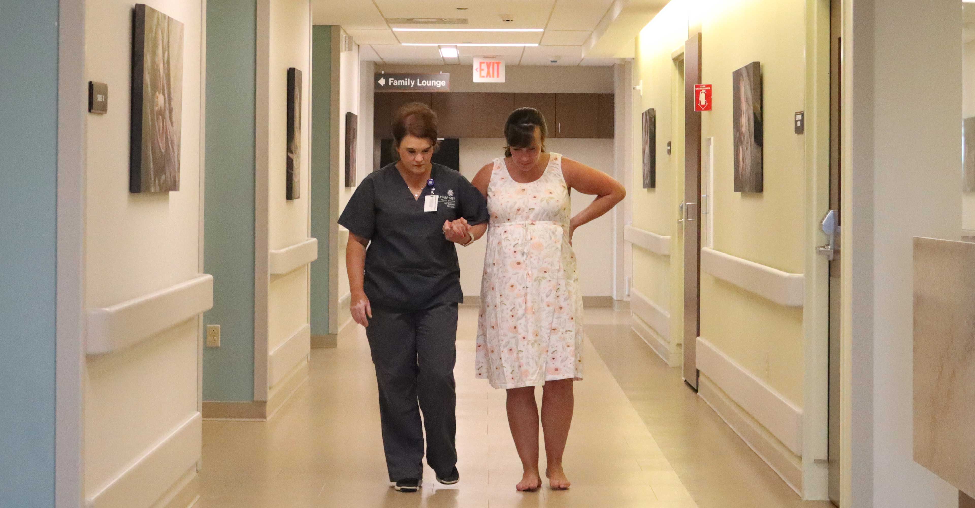 Doula helping a pregnant mothers walking down the hall during labor and delivery