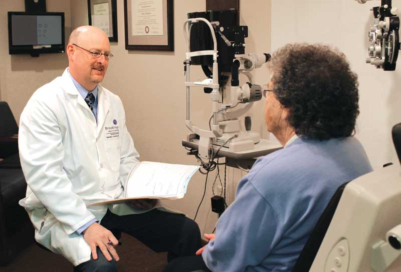 Ophthalmologist Dr. Ken Knudtson in an eye exam room with a patient