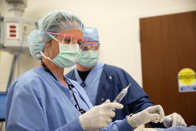 Nurse anesthetist preparing for an injection inside the operating room