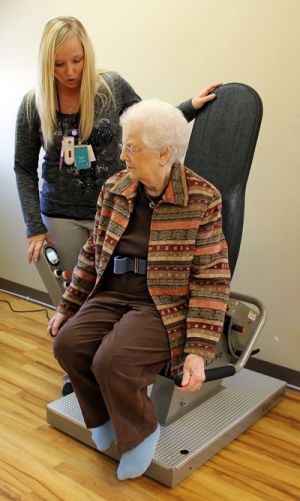 Resident working with therapist on exercise equipment