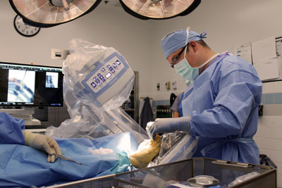 Dr. Trevor Haynes, podiatrist at Avera Medical Group, performs a procedure on a patient’s foot in Brookings Health System’s operating room with the aid of the new mini C-arm fluoroscope. The live, video-like X-ray technology allows surgeons to view patient anatomy on a screen in real-time, helping them guide instruments during procedures and place medical implants, such as screws, wires or plates.