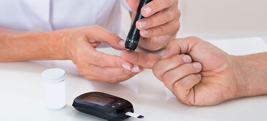 Physician checking diabetic patient's blood sugar
