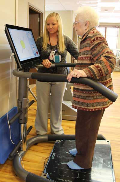 Dorothy Schaller, a resident at The Neighborhoods at Brookview, works on a balance exercise under the direction of Physical Therapy Assistant Amanda Sinkular. The new balance analysis system is one of five new pieces of therapy equipment acquired by the facility. The Neighborhoods is the first nursing home in South Dakota to deploy HUR strength and power equipment.