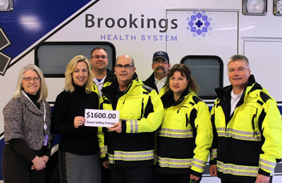 Debra Biever, director of customer and employee relations at Sioux Valley Energy, delivers a donation of $1,600 from Operation Round Up. Accepting the check are Brookings Health System Foundation Development Officer Barb Anderson along with ambulance staff Mike Hanson, Gordon Dekkenga, Tim Austin, Sheila Monnier and Tom Papiernik.