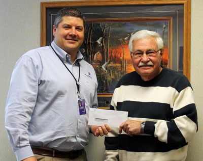 Brookings Health System CEO Jason Merkley presents a $5,000 check to Don Boone of the Volunteer Service Bank. The organization matches volunteers with people and projects needing help within Brookings County. 