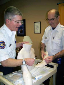 Paramedic Tom Papiernik (left) and Ambulance Director Gordon Dekkenga use the new training simulator to determine access for a central line, an infusion tube that is routed to a large vein near the heart. Funded by Brookings Health System Foundation, the new simulator will help paramedics better serve patients with central lines