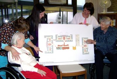 Brookview Manor residents and staff look over the spacious floor plan for The Neighborhoods at Brookview. From left to right are Resident Dorothy Elaine Connolly, LPN Mona Dykhouse, CNA Caley Lundberg, Neighborhood Coordinator Mona Williams, and Honorary Campaign Chair and Resident Ray LaRoche.