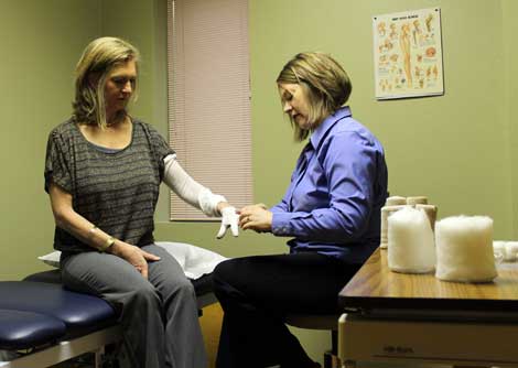 Physical Therapist Karen Skogstad (right) demonstrates bandaging techniques that help reduce swelling caused by lymphedema. 