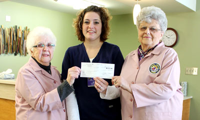 Brookings Healthcare Auxiliary President Marlys Kelsey (right) and Treasurer Ruth Hevle present a check to Outreach Specialty Clinic Facilitator Jen Chandler, RN, for the new stretcher bed that aids health care providers in administering pain management treatments.